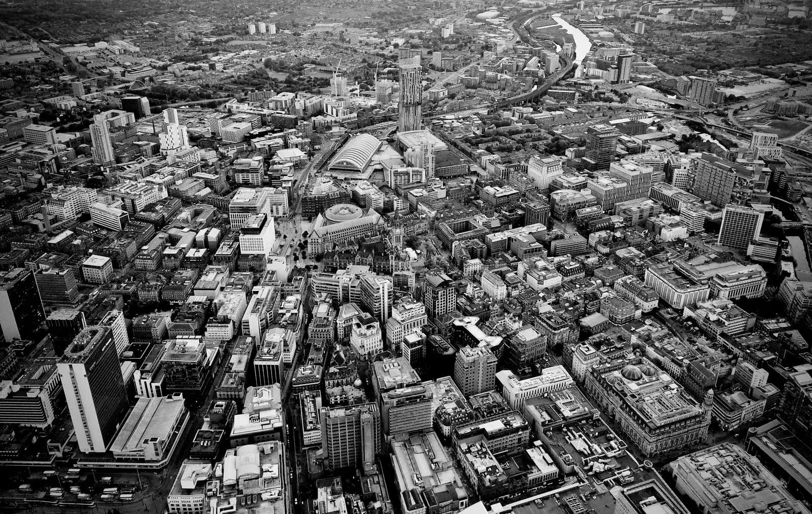 Manchester city centre seen from above, with streets of offices and older brick buildings.