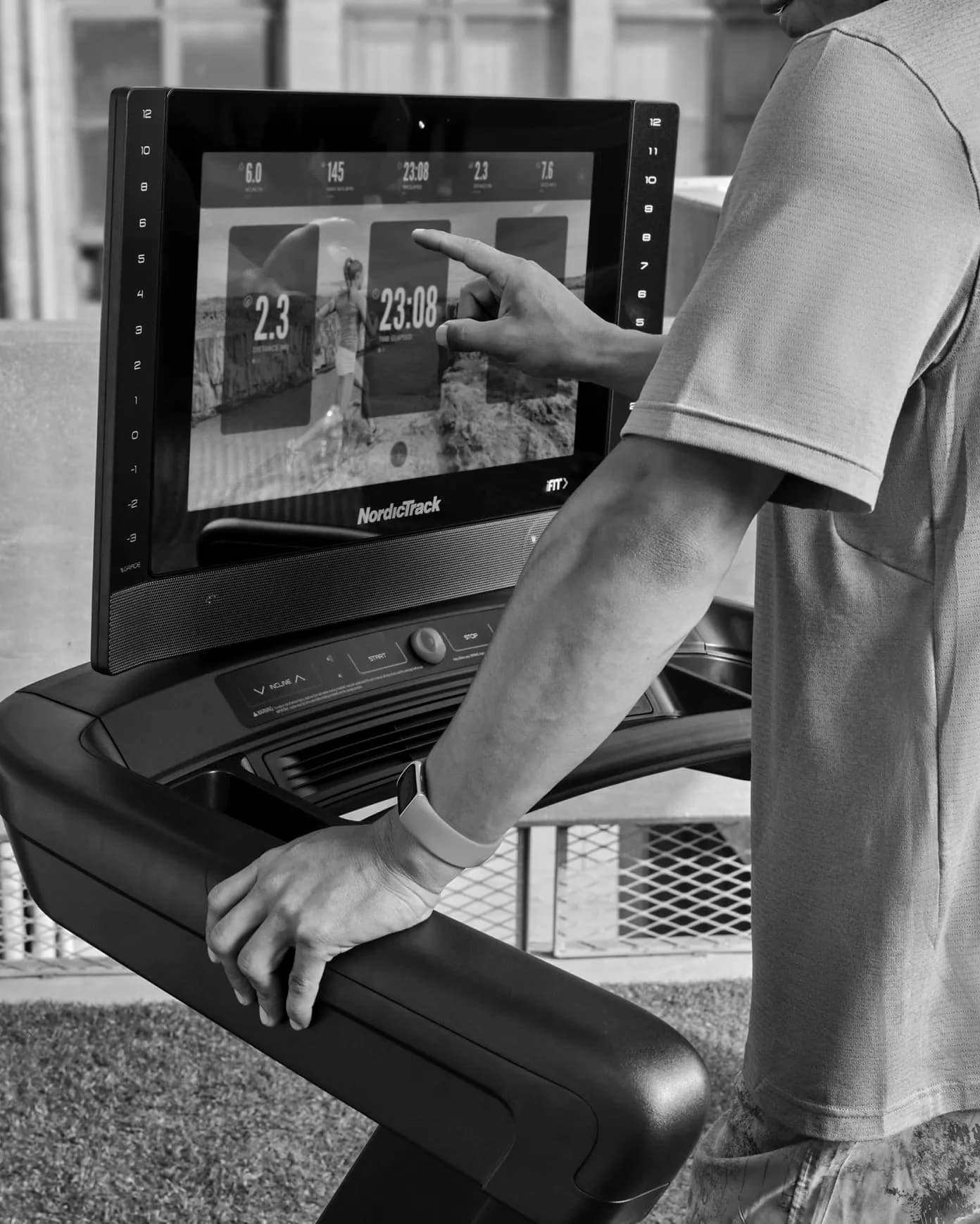 Runner on a treadmill wearing a Fitbit Charge 6 while adjusting the treadmill console