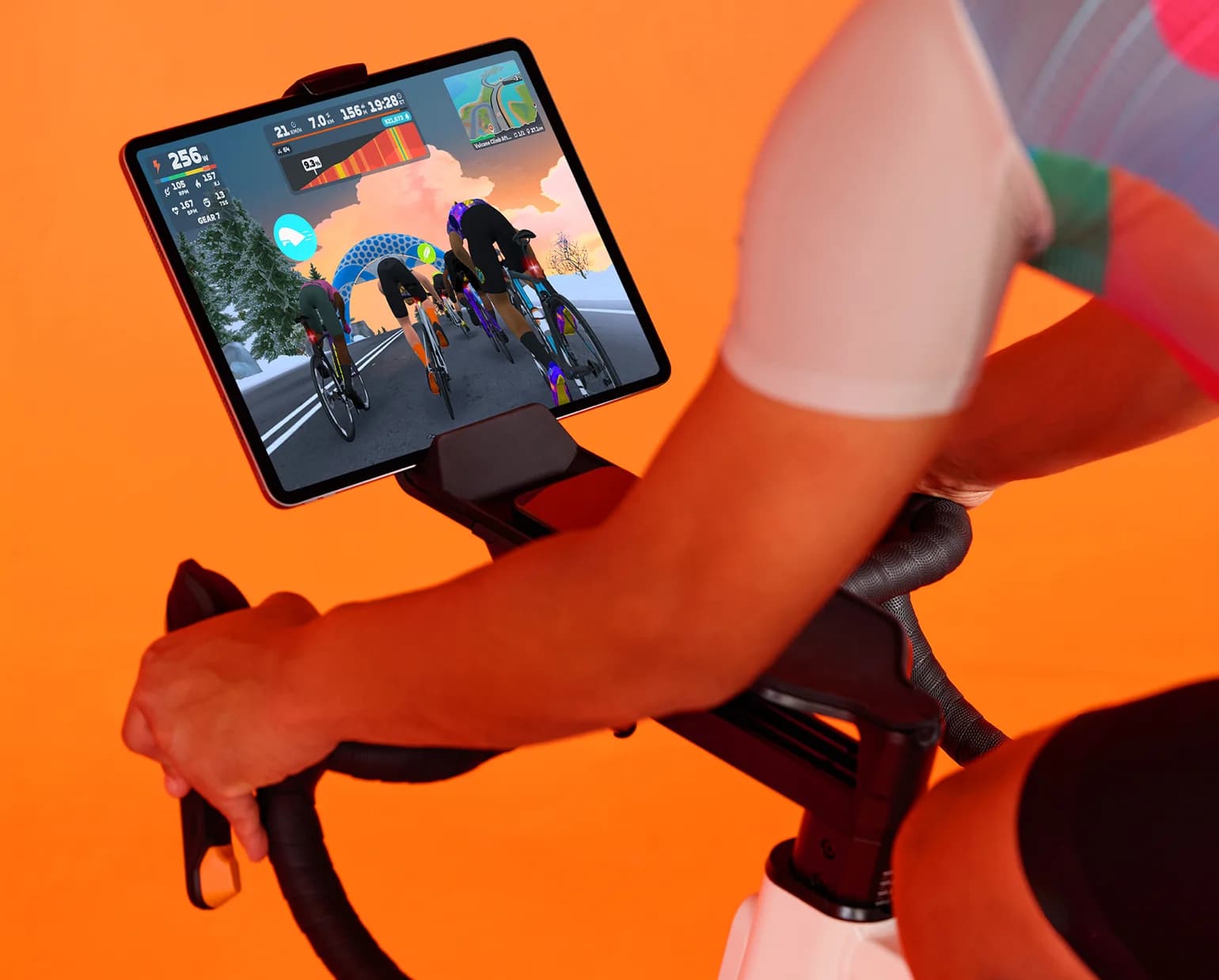 Rider on a smart trainer following a Zwift ride on a tablet